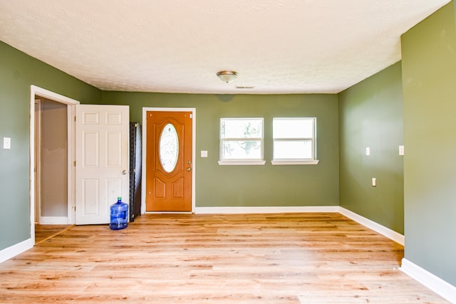 foyer with light hardwood / wood-style floors and a textured ceiling