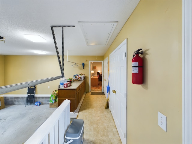 hallway featuring light tile patterned floors and a textured ceiling