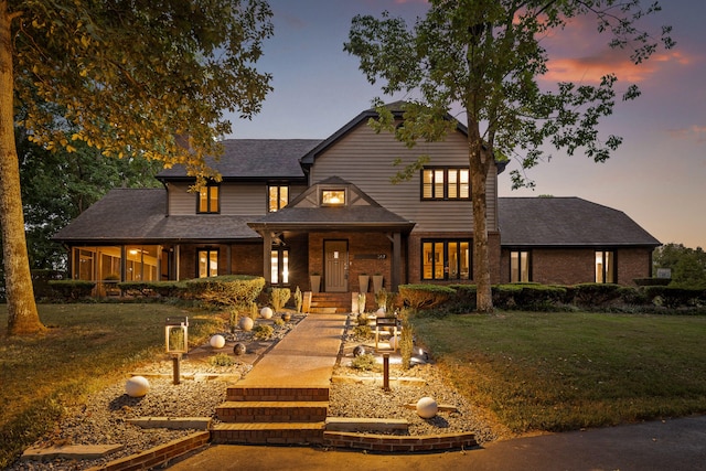 view of front facade featuring covered porch and a lawn