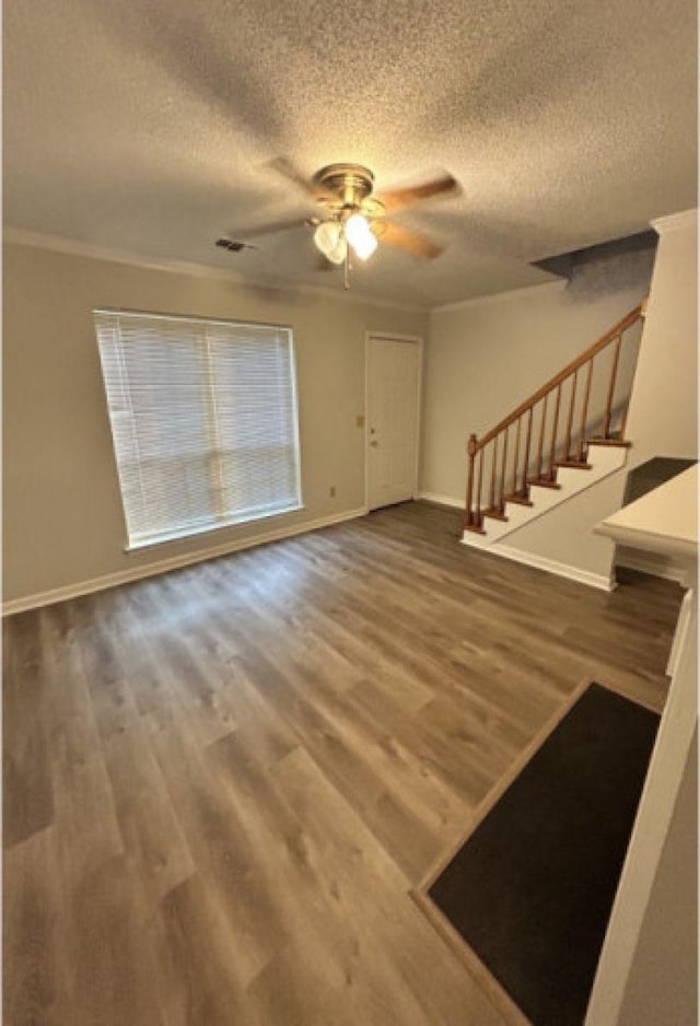 interior space featuring a textured ceiling, stairway, wood finished floors, and baseboards