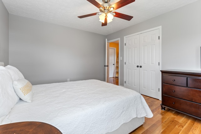 bedroom featuring ceiling fan, light hardwood / wood-style flooring, and a closet