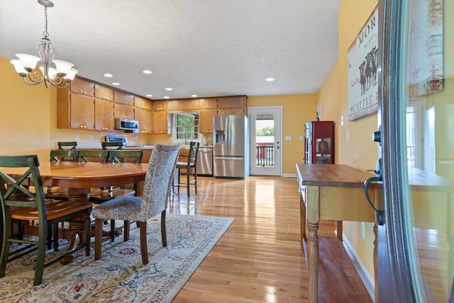 dining area featuring light hardwood / wood-style flooring and a chandelier