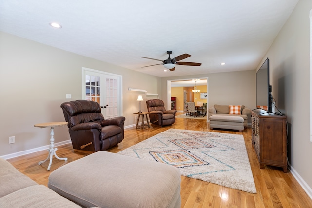 living room featuring ceiling fan, light wood-type flooring, and french doors