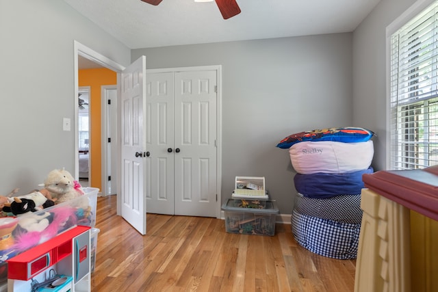 bedroom featuring light hardwood / wood-style flooring, ceiling fan, and a closet