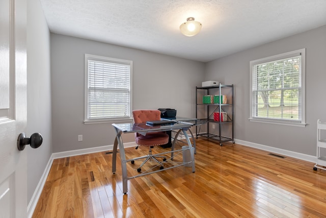 office area featuring light hardwood / wood-style flooring and a textured ceiling