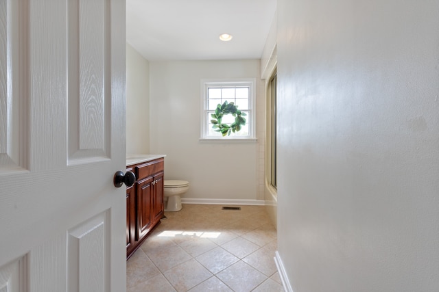 bathroom featuring tile patterned flooring, toilet, and vanity