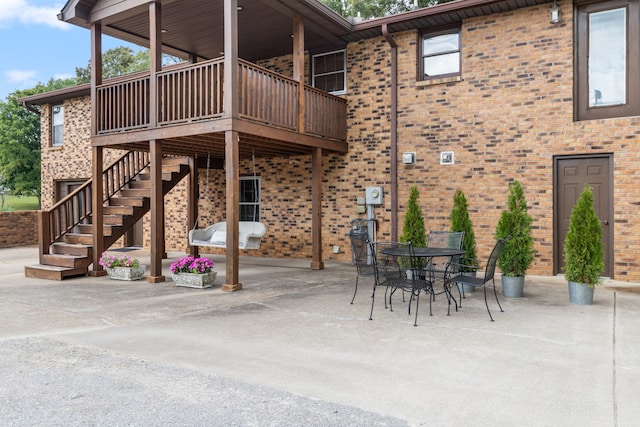 rear view of property featuring a wooden deck and a patio area