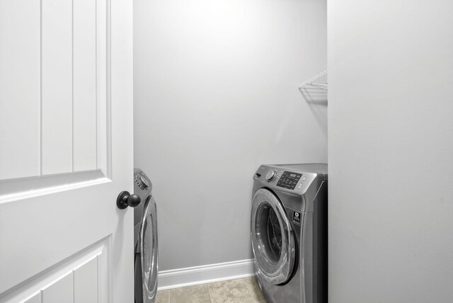 washroom featuring light tile patterned flooring and washer and dryer