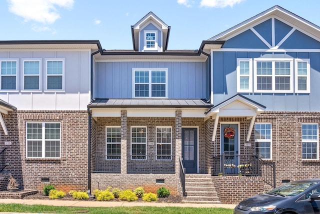 townhome / multi-family property with board and batten siding, crawl space, and brick siding