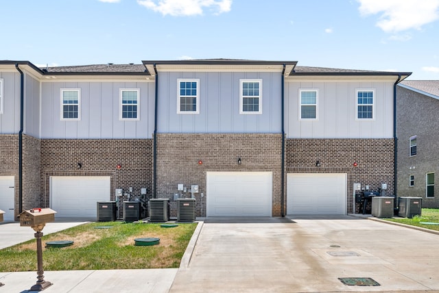 view of front of property featuring central air condition unit and a garage