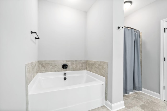 bathroom with curtained shower, tile patterned floors, a bath, and baseboards