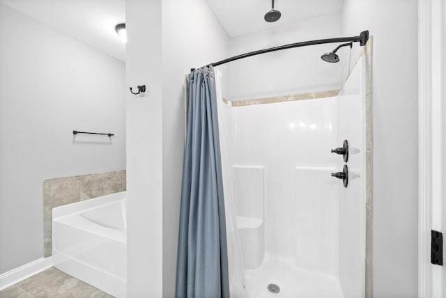 bathroom featuring a shower stall and a bath