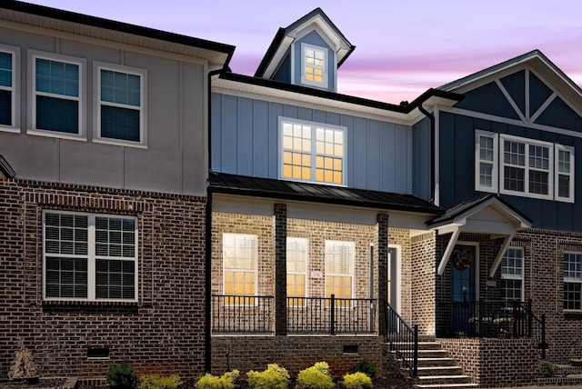 multi unit property featuring crawl space, a standing seam roof, board and batten siding, and brick siding