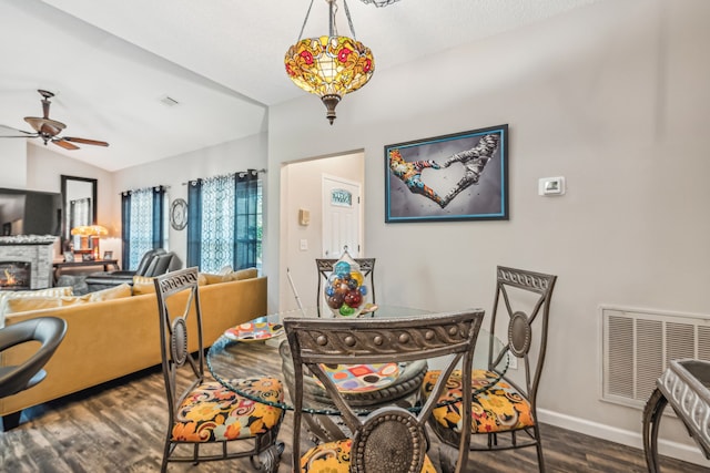 dining room with ceiling fan, dark hardwood / wood-style floors, and lofted ceiling