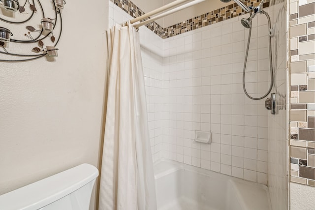 bathroom featuring toilet and shower / bath combo with shower curtain