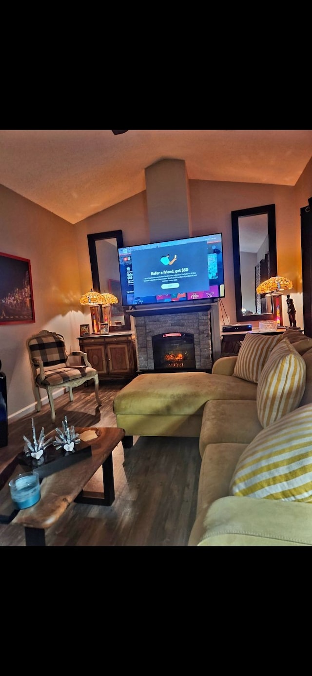 living room featuring hardwood / wood-style flooring, a fireplace, and vaulted ceiling