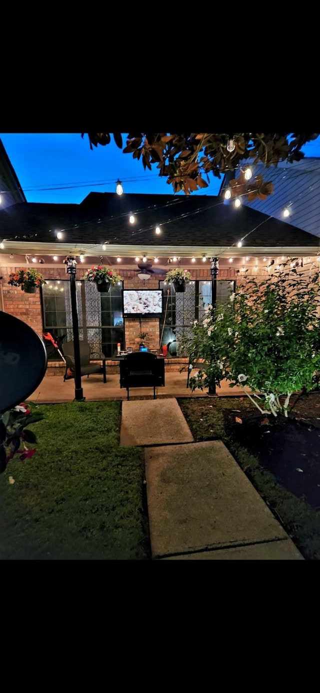 patio at night featuring a yard