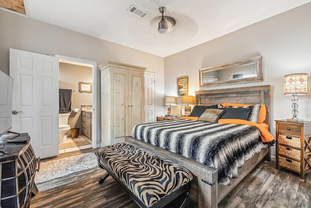 bedroom with tile patterned flooring, ceiling fan, a textured ceiling, and ensuite bath