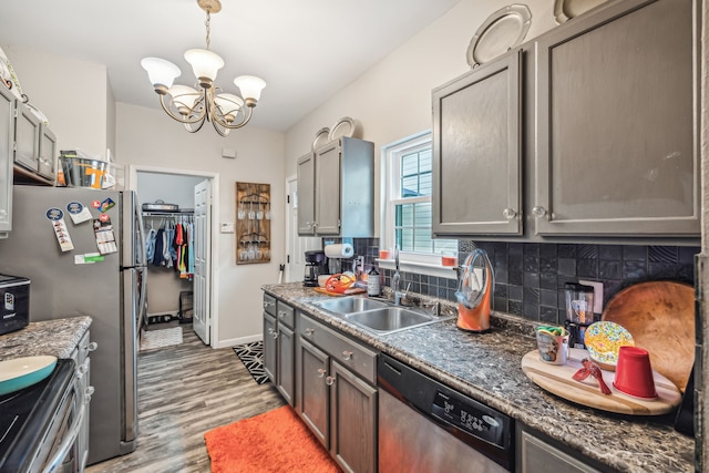 kitchen featuring appliances with stainless steel finishes, light hardwood / wood-style floors, a chandelier, tasteful backsplash, and sink