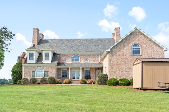 view of front of home with a storage shed and a front lawn