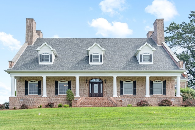 cape cod home featuring a porch and a front lawn