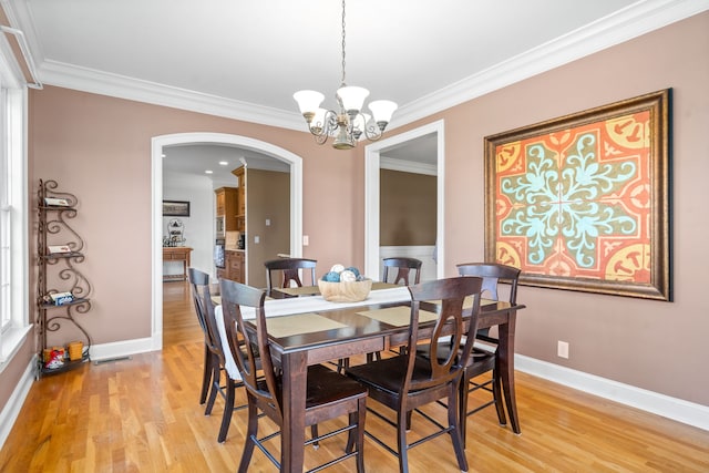 dining room featuring light hardwood / wood-style floors, a chandelier, and ornamental molding