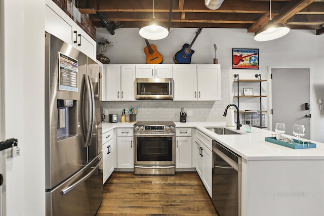 610 21st Ave N Unit 101, Nashville, TN 37203 - kitchen featuring appliances with stainless steel finishes, a sink, a peninsula, dark wood finished floors, and white cabinets
