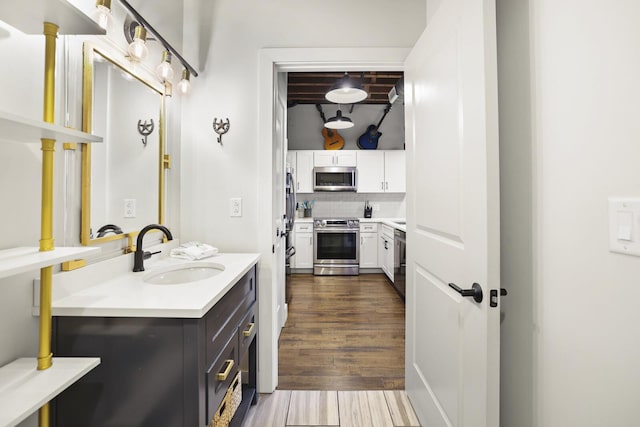 610 21st Ave N Unit 101, Nashville, TN 37203 - bathroom featuring wood finished floors, tasteful backsplash, and vanity