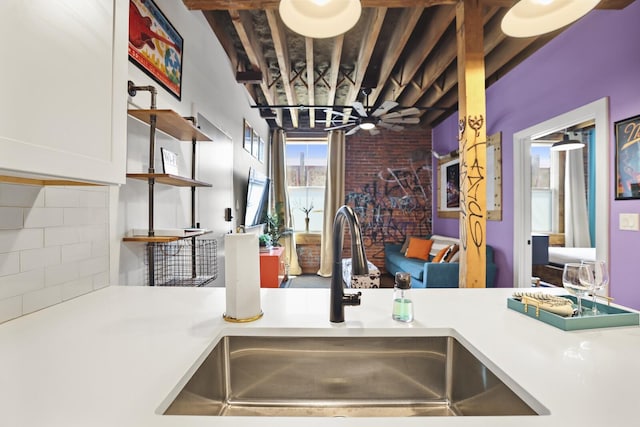 610 21st Ave N Unit 101, Nashville, TN 37203 - kitchen with a sink, decorative backsplash, light countertops, open shelves, and white cabinets