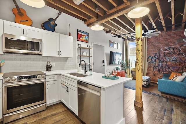 610 21st Ave N Unit 101, Nashville, TN 37203 - kitchen with appliances with stainless steel finishes, a sink, a peninsula, backsplash, and light countertops