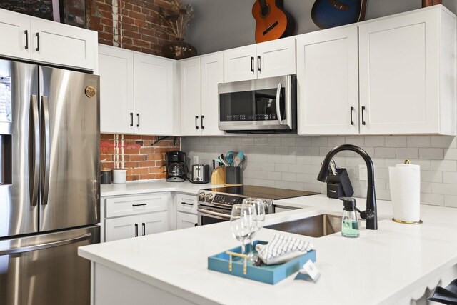 610 21st Ave N Unit 101, Nashville, TN 37203 - kitchen featuring stainless steel appliances, light countertops, white cabinetry, and tasteful backsplash