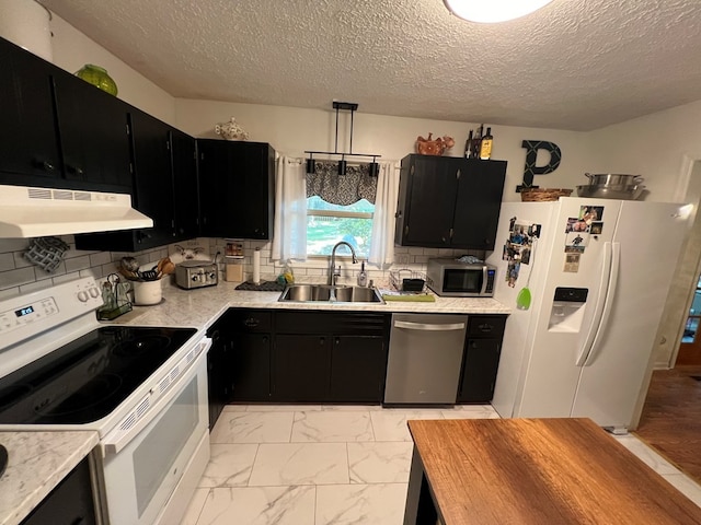 kitchen with sink, stainless steel appliances, pendant lighting, and tasteful backsplash