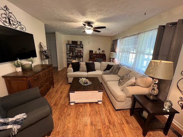 living room featuring a textured ceiling, ceiling fan, and hardwood / wood-style floors