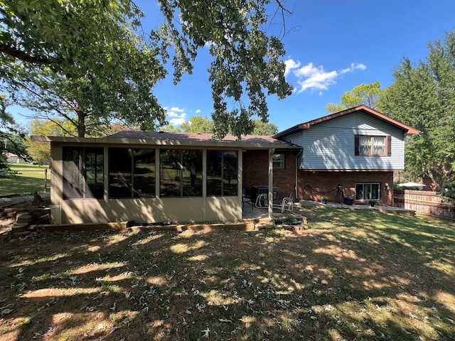 rear view of house with a sunroom and a yard