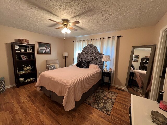 bedroom featuring ceiling fan, dark hardwood / wood-style floors, and a textured ceiling