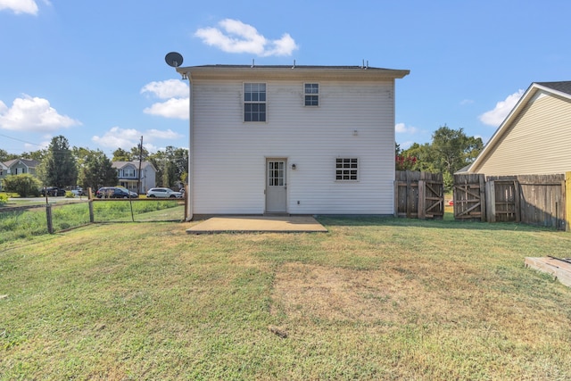 back of house featuring a patio and a yard