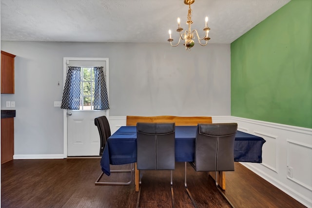 dining room featuring a textured ceiling, an inviting chandelier, and dark hardwood / wood-style floors