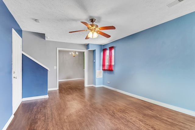 spare room with dark hardwood / wood-style flooring, a textured ceiling, and ceiling fan with notable chandelier