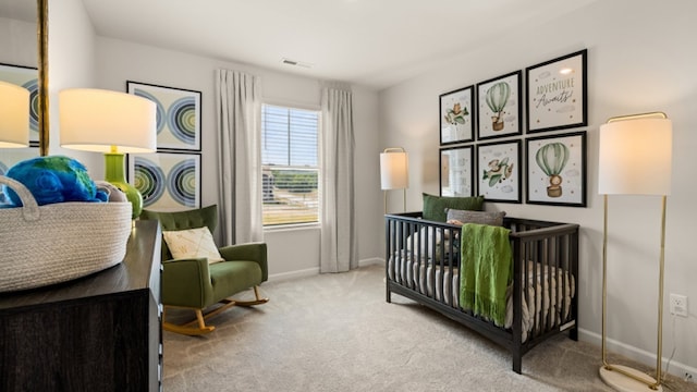 bedroom featuring a nursery area and light carpet