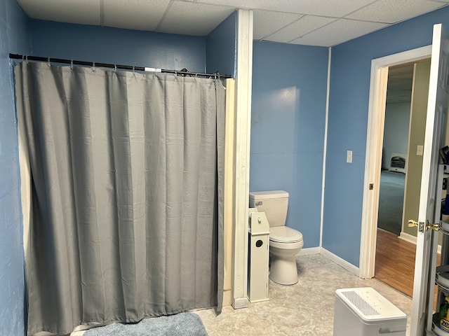 bathroom featuring a drop ceiling, wood-type flooring, and toilet