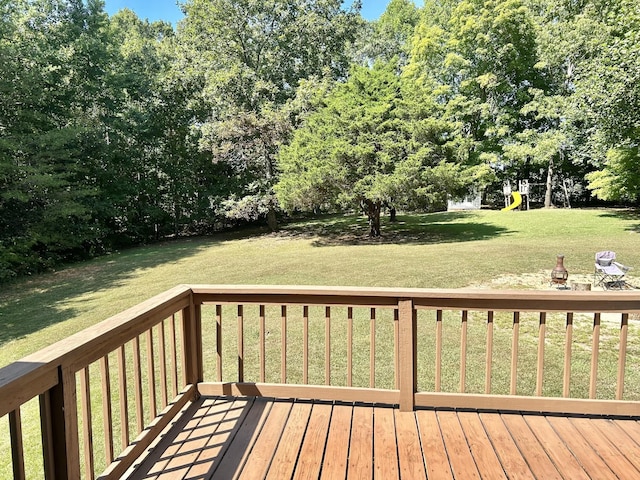 deck featuring a playground and a yard