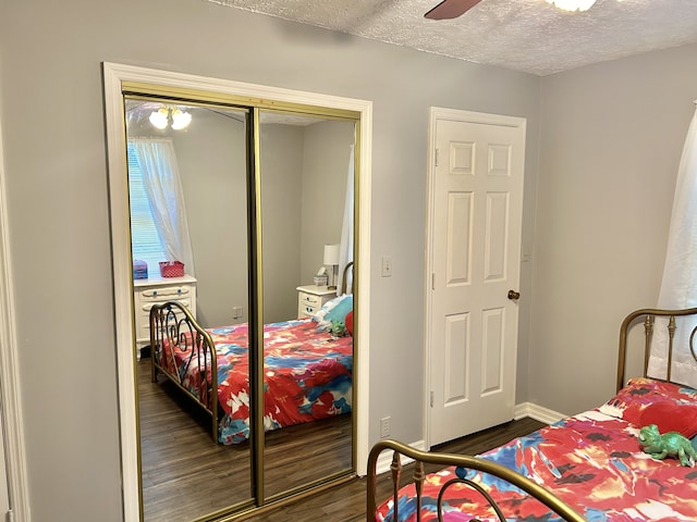 bedroom with dark hardwood / wood-style flooring, a closet, a textured ceiling, and ceiling fan