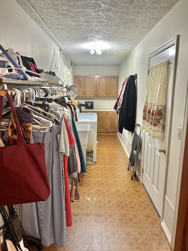 spacious closet featuring light tile patterned floors and washing machine and clothes dryer