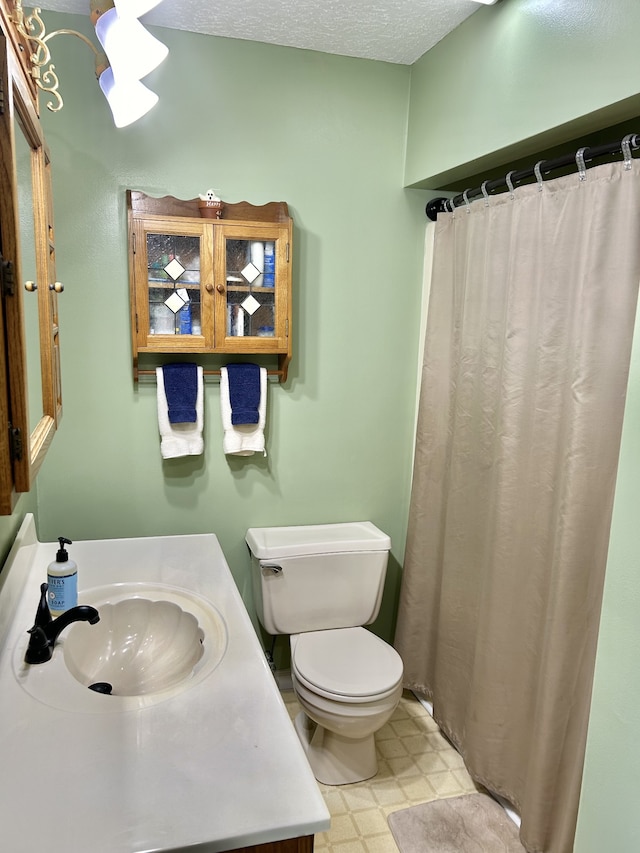 bathroom featuring tile patterned floors, a textured ceiling, vanity, toilet, and a shower with curtain