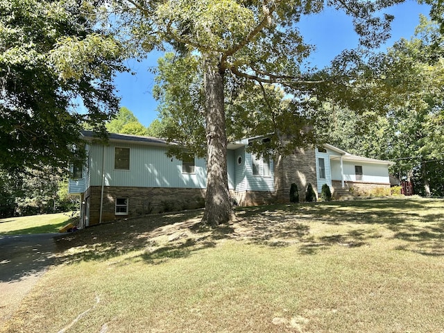 view of front of property featuring stone siding and a front yard