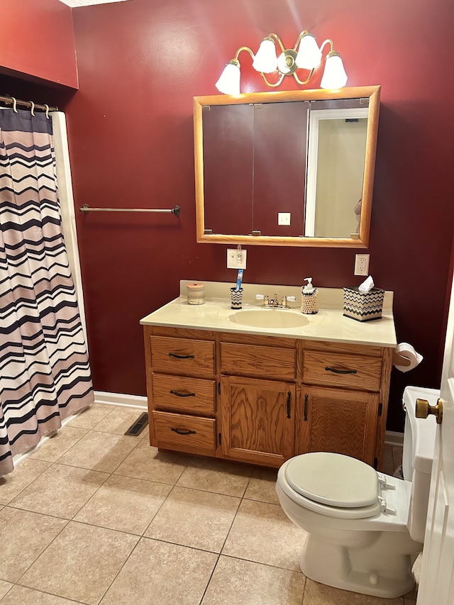 bathroom with tile patterned flooring, vanity, and toilet