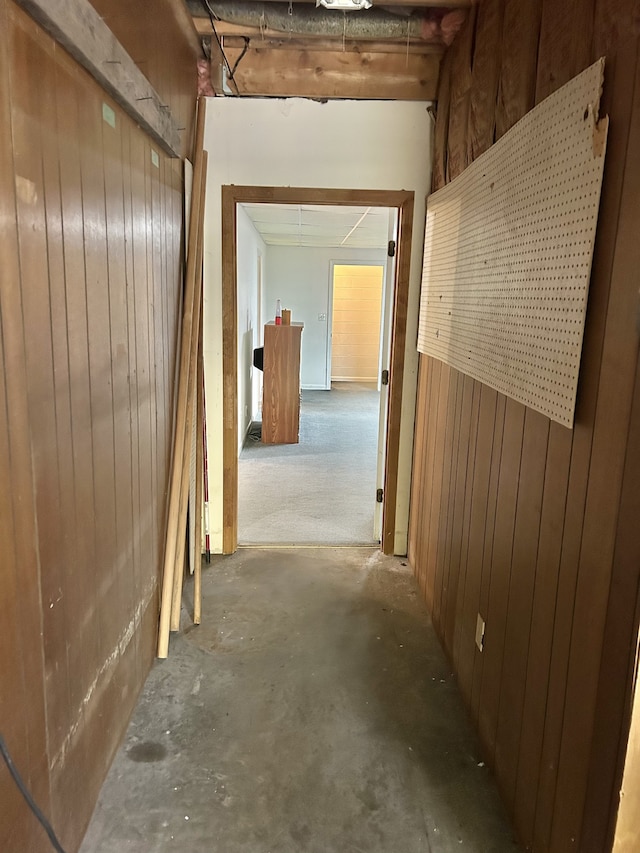 corridor with concrete floors and wooden walls