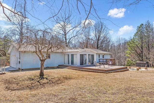 rear view of property with a lawn and a wooden deck