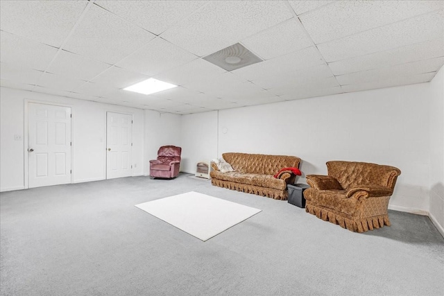 living area with carpet, baseboards, and a paneled ceiling