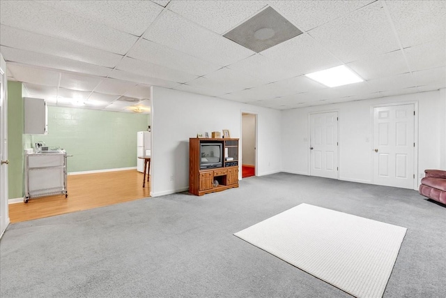 finished basement with carpet flooring, baseboards, and a drop ceiling